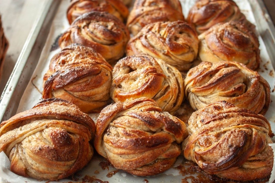 Nybakade, gyllenbruna kardemummabullar på en plåt